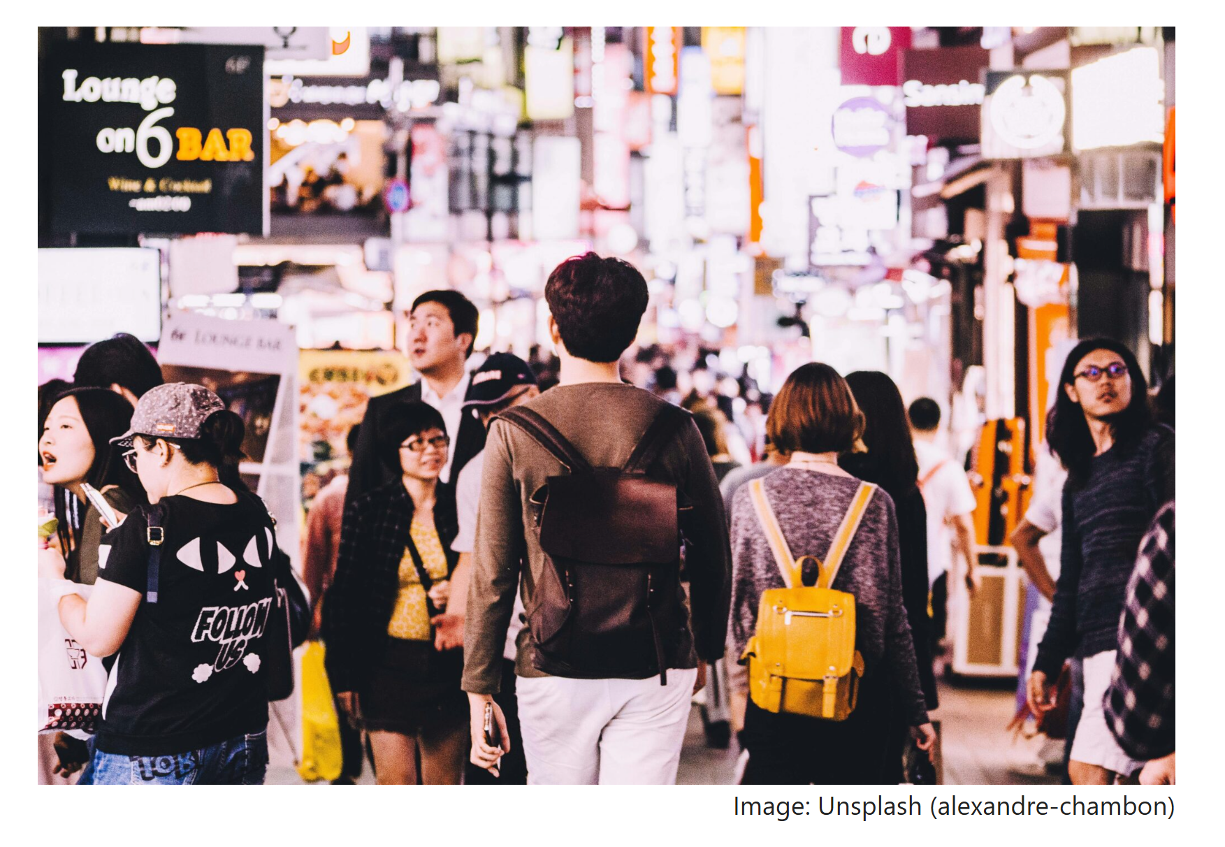 People walking through a crowded city street at night, adjusting their pace and direction without speaking