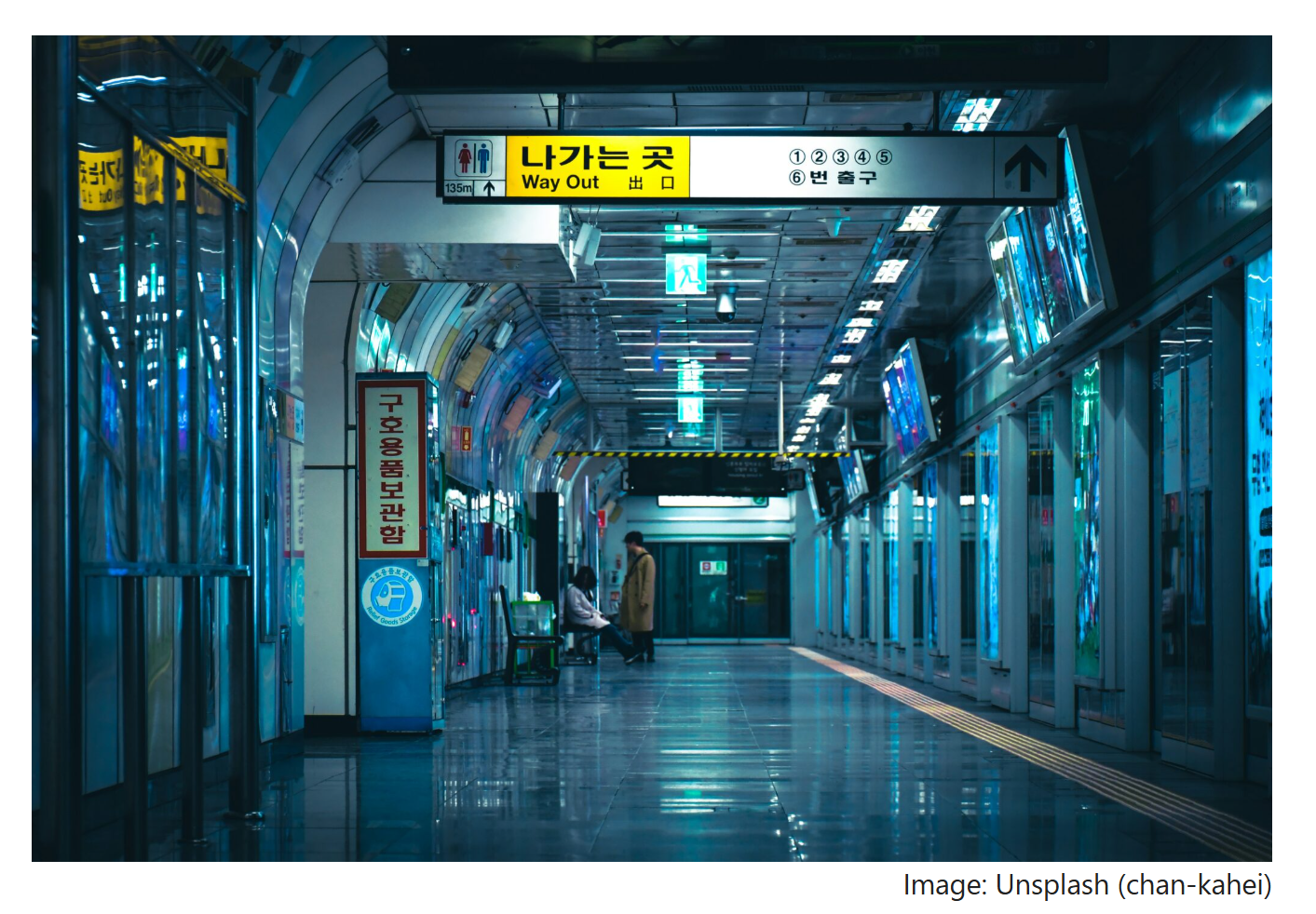The interior of a Seoul subway station at night, featuring platform screen doors and blue-toned lighting that conveys a modern, safe atmosphere.